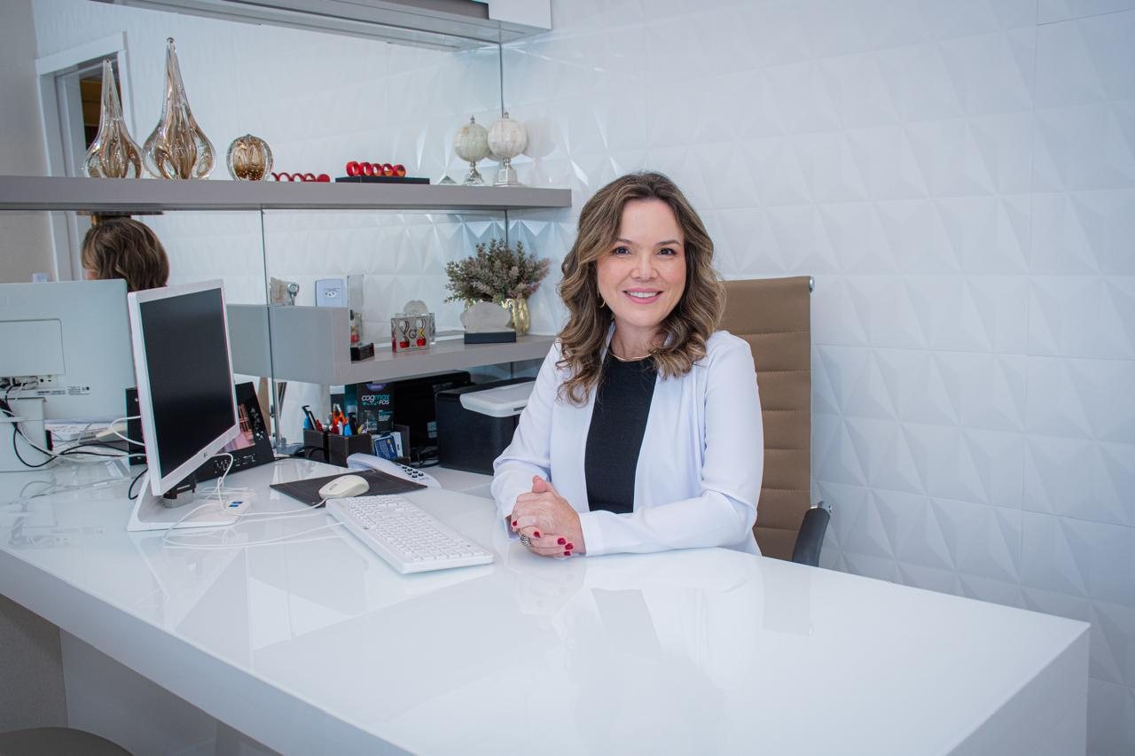Dra. Renata Moretto sorrindo em seu consultório